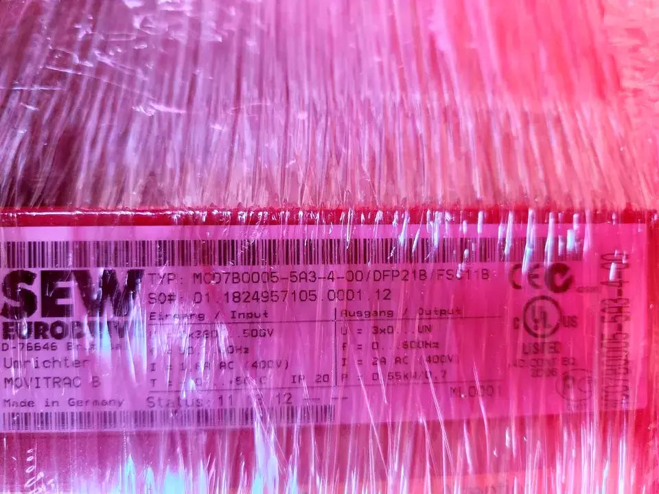 Close-up of SEW Movitrac 08285179 MC07B0005-5A3-4-00 drive label, showing specifications and barcode under protective wrapping.