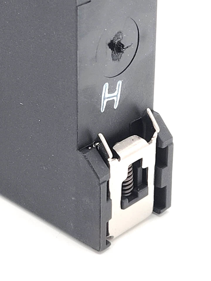 Close-up of Telemecanique / Schneider Electric XPSBA5120 Zweihand-Steuergerät 24V AC/DC showing part of the casing and a metal clip.