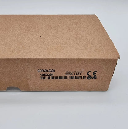 Verpackung des Sick 1052291 CDF600-0300 Netzwerkgerät CDF, mit Artikelnummer und Serieninformationen sichtbar.