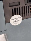 Label on electronic equipment stating 'No warranty if seal is broken.'