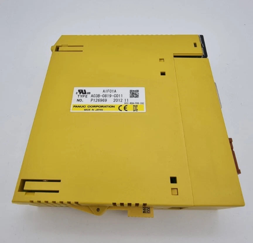 Yellow Fanuc A03B-0819-C011 CNC I/O-Modul on white background, new and unused, with label showing model details.