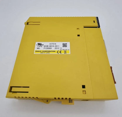 Yellow Fanuc A03B-0819-C011 CNC I/O-Modul on white background, new and unused, with label showing model details.