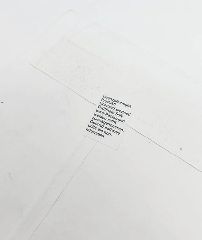Close-up of a sealed product label in multiple languages, indicating non-returnable and licensed product conditions.