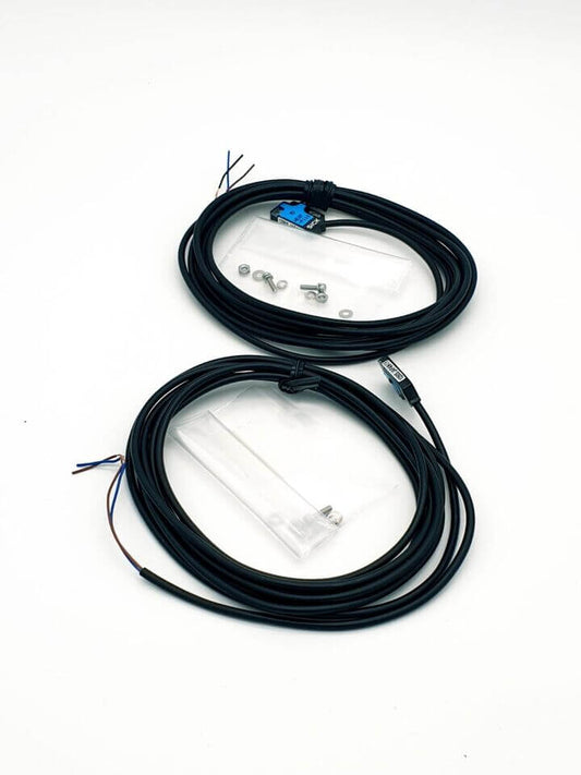 Black electrical cables with connectors and small screws on a white background