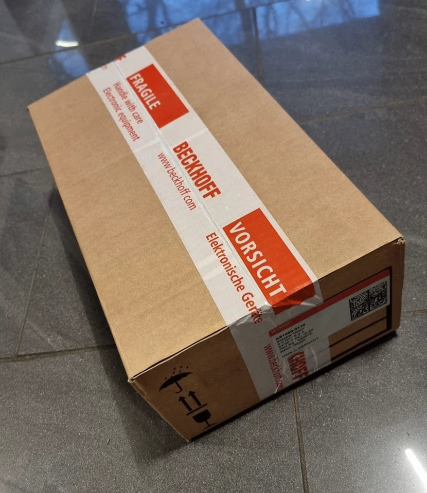 Sealed Beckhoff AS1060-0110 Schrittmotor in original packaging, box labeled with caution and fragile signs.