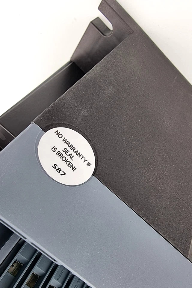 Sticker with 'No warranty if seal is broken' on electronic equipment.